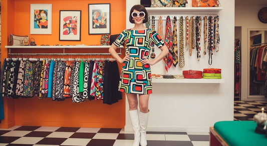 1960s-inspired mod fashion for women featuring a shift dress, go-go boots, and bold accessories in a retro boutique